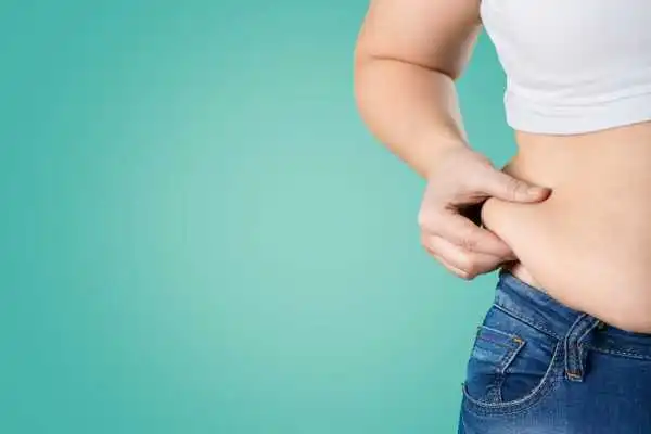 Image of woman pinching her love handles to show weight gain Melksham